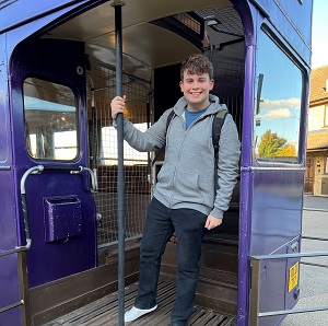 Picture of Marcus standing on a blue double decker bus